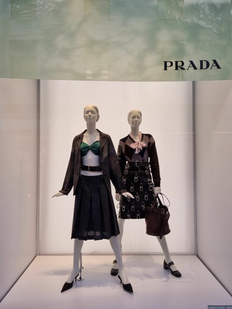 Witryna sklepu Prada w Mediolanie z manekinami ubranymi w nowe kolekcje