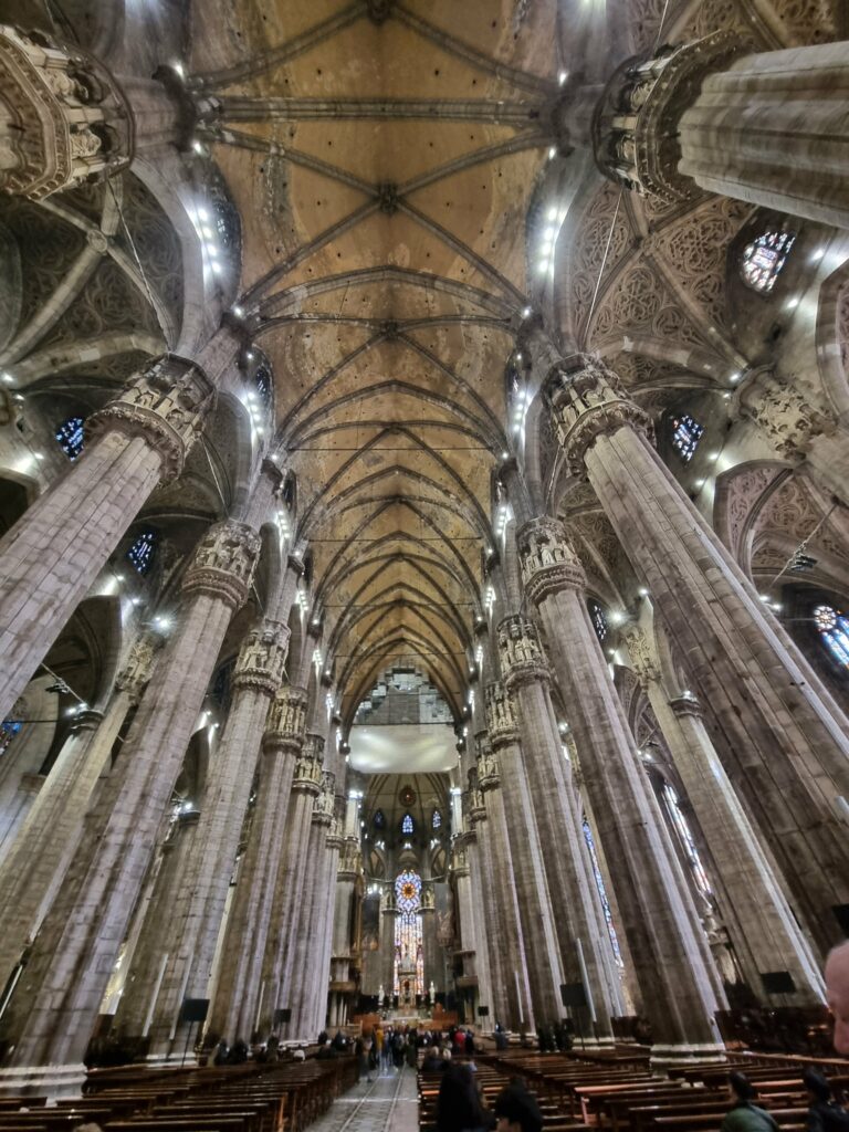 Monumentalne wnętrze Katedry Duomo w Mediolanie z gotyckimi kolumnami i sklepieniem
