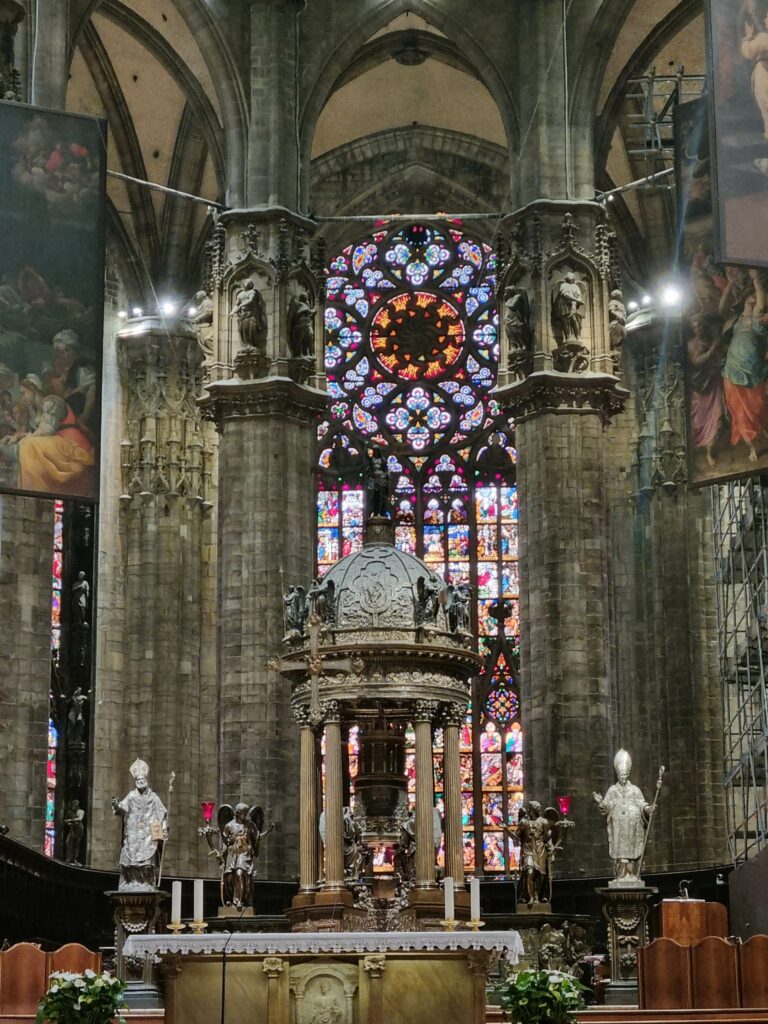 Główny ołtarz Katedry Duomo z baldachimem i witrażami w tle