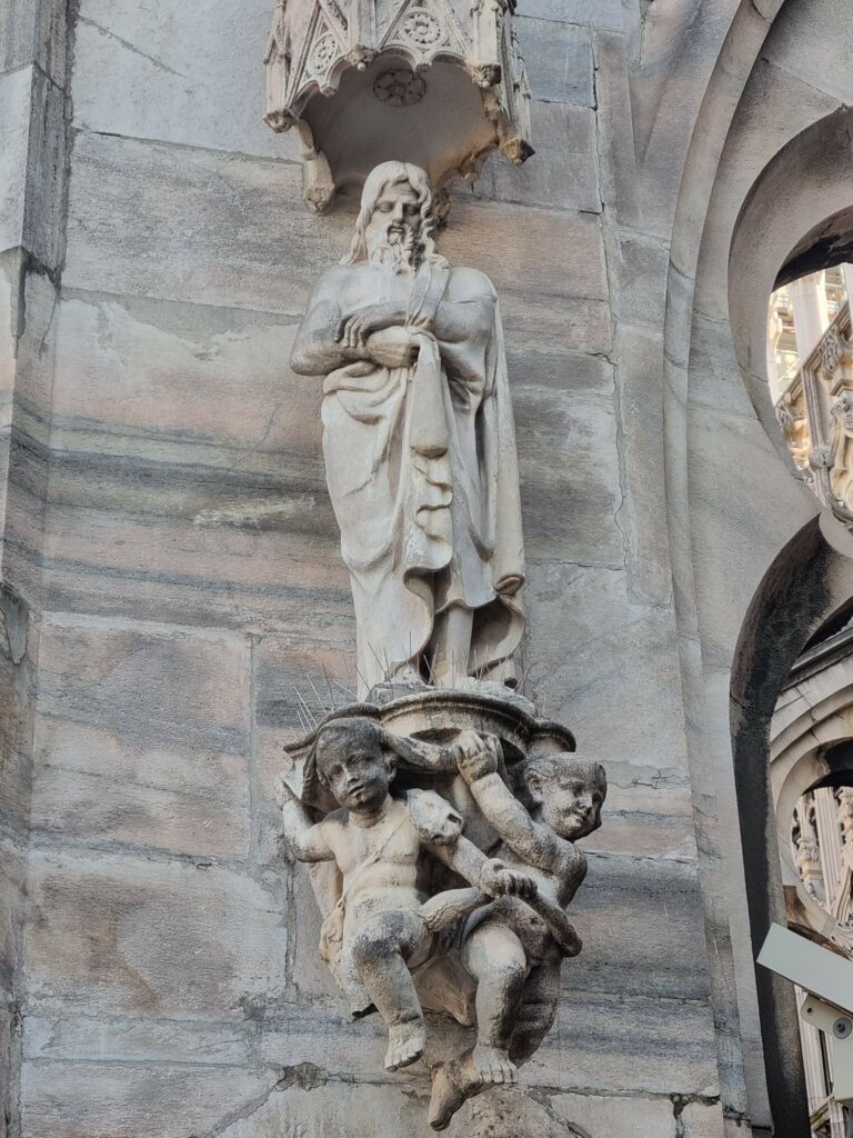 Kamienna rzeźba świętego z aniołkami na fasadzie Katedry Duomo w Mediolanie
