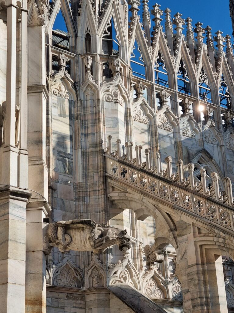 Gotycki gargulec i dekoracje na bocznej ścianie Katedry Duomo