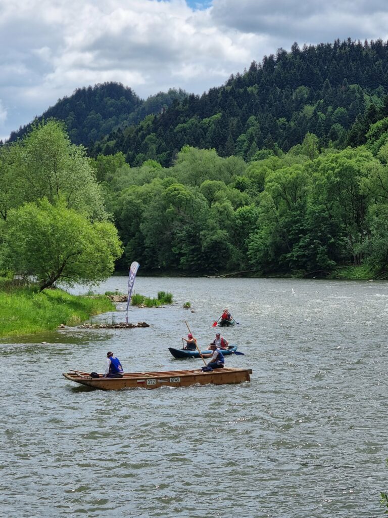 Flisacy i kajakarze na rzece Dunajec w otoczeniu gór i lasów