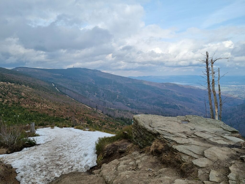 Widok na Beskid Śląski, fragmenty śniegu na ziemi, widoczna góra Barania Góra w oddali