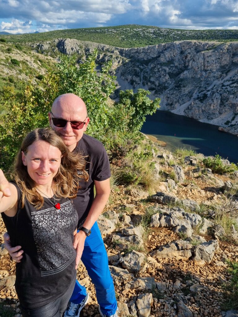 Para robiąca sobie selfie na punkcie widokowym nad Kanionem Zrmanje w Chorwacji, w tle skaliste zbocza i rzeka.
