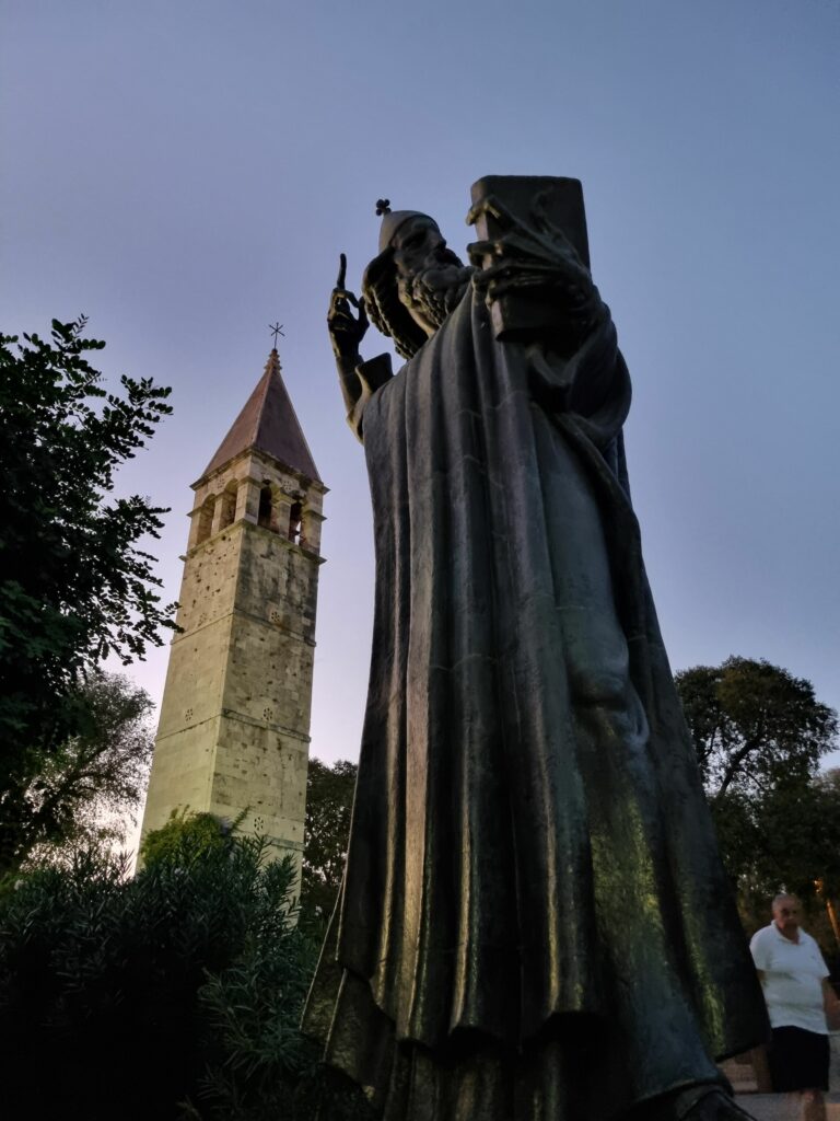 Imponujący pomnik Grzegorza z Ninu (Grgur Ninski) w Splicie, uchwycony o zmierzchu. Postać biskupa stoi dumnie tuż za Złotą Bramą Pałacu Dioklecjana.