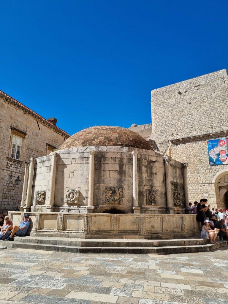 Wielka Fontanna Onufrego i lśniące wapienne płyty na ulicy Stradun w Dubrowniku.