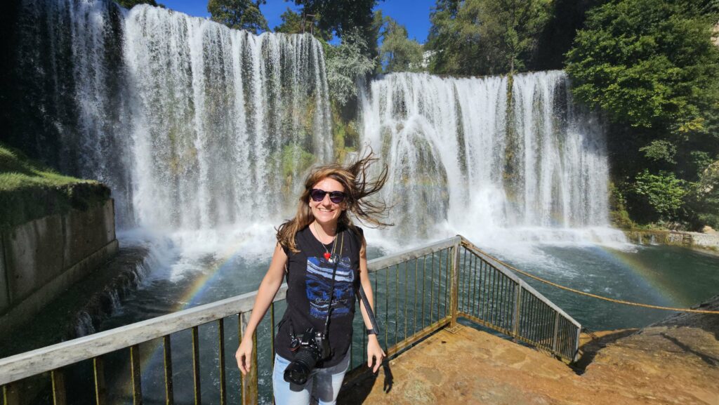 Potężny wodospad w Jajce, gdzie rzeka Pliva wpada do Vrbasu, z tarasem widokowym w tle, Bośnia i Hercegowina.