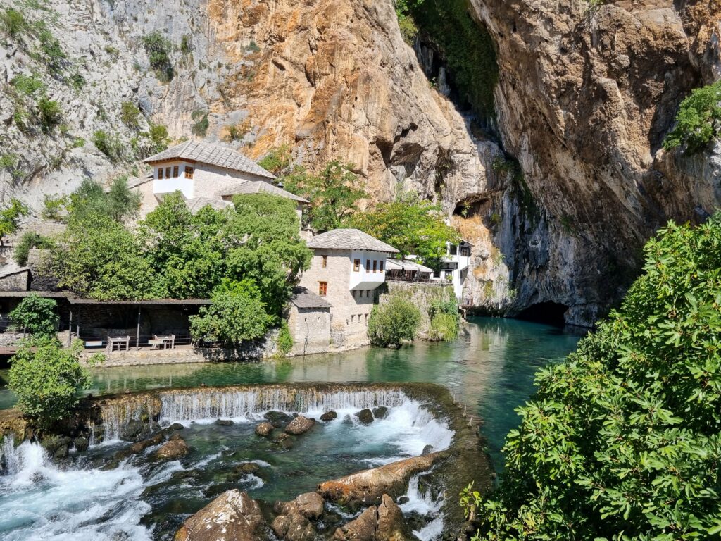 Magiczne zderzenie natury i duchowości – klasztor w Blagaj, gdzie krystalicznie czysta rzeka Buna wypływa prosto z wnętrza potężnej skały.