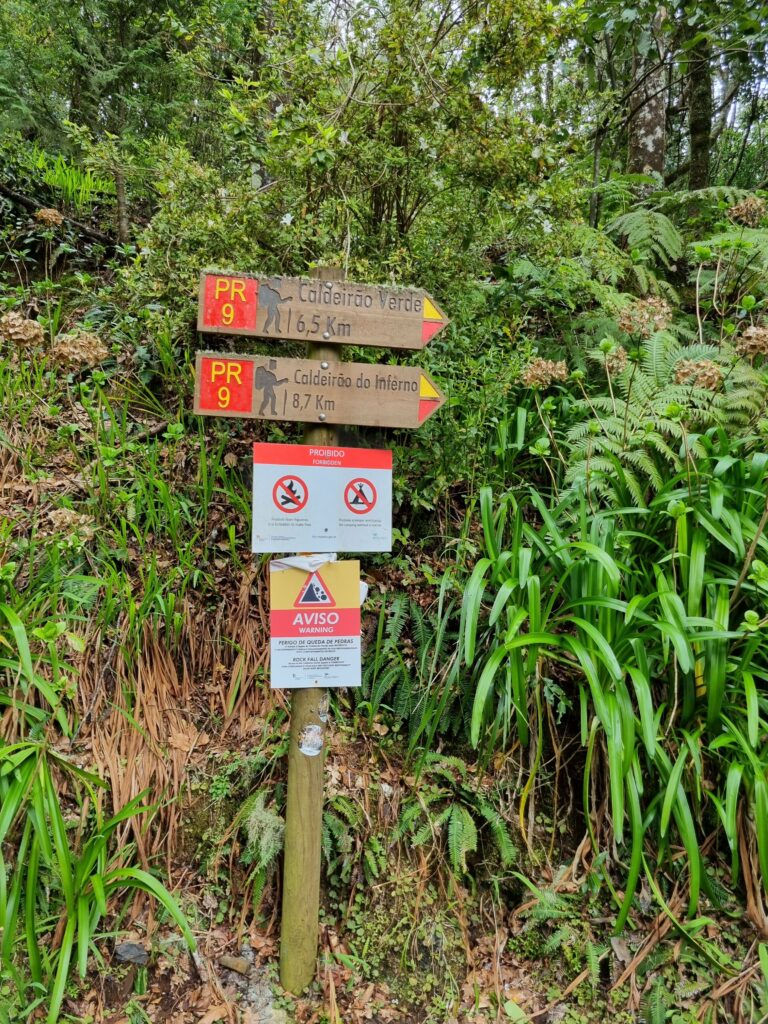 Drewniany drogowskaz turystyczny na szlaku PR 9 wskazujący kierunek do wodospadu Caldeirão Verde na Maderze.