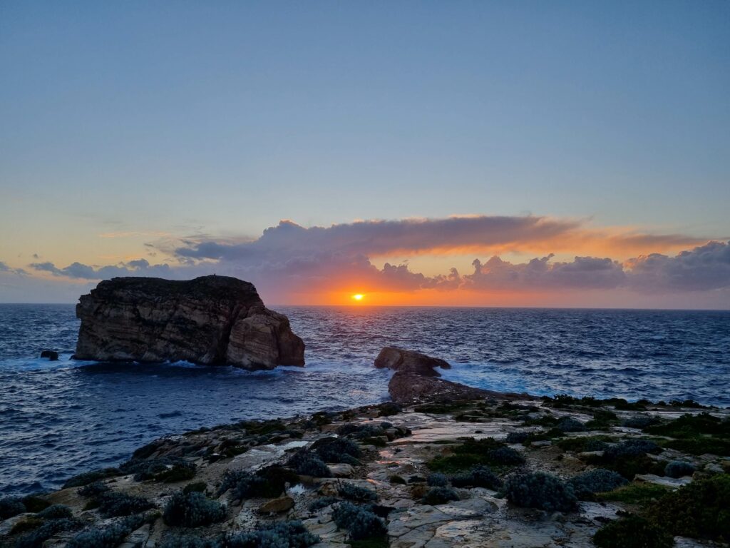 Spektakularny zachód słońca w zatoce Dwejra na Gozo przy Blue Hole