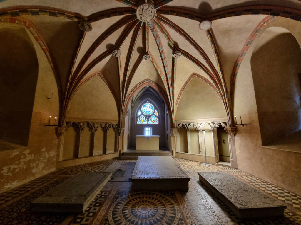 Wnętrze gotyckiej kaplicy na Zamku Wysokim w Malborku z płytami nagrobnymi wielkich mistrzów krzyżackich i gwiaździstym sklepieniem.