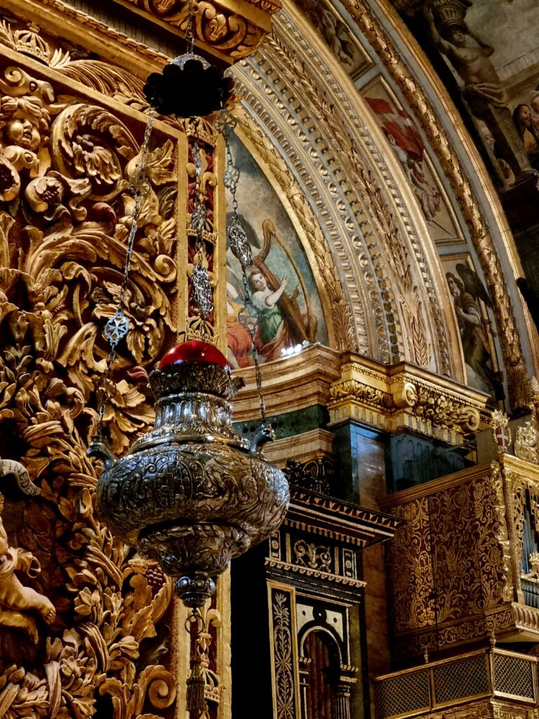 Imponujący ołtarz główny w Konkatedrze św. Jana w Valletcie z marmurowymi rzeźbami i barokowym przepychem.