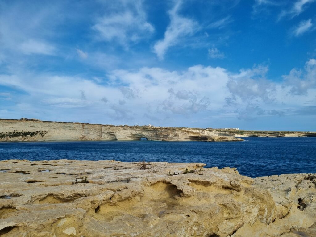Wysokie wapienne klify otaczające turkusową zatokę St. Peter’s Pool na południowym wybrzeżu Malty.