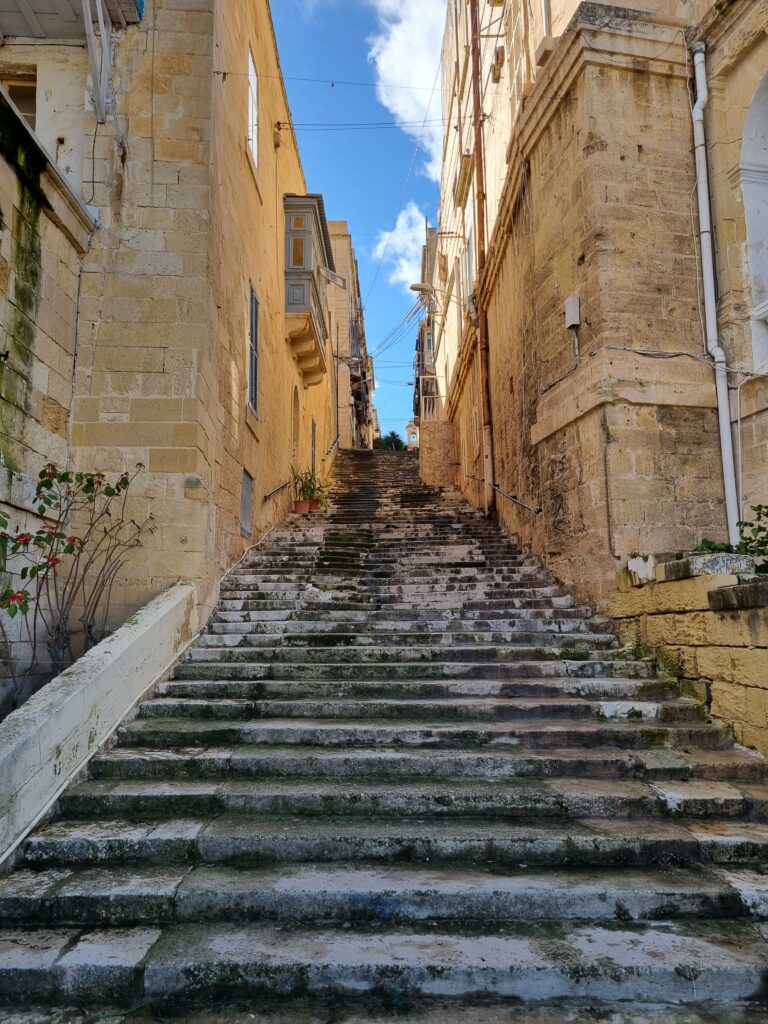 Malownicze, strome schody prowadzące przez wąskie uliczki historycznego Birgu w Trzech Miastach na Malcie.