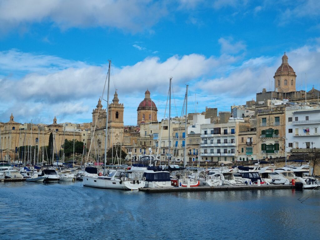 Widok na ufortyfikowane nabrzeże Trzech Miast na Malcie z pokładu tradycyjnej łodzi dgħajsa.