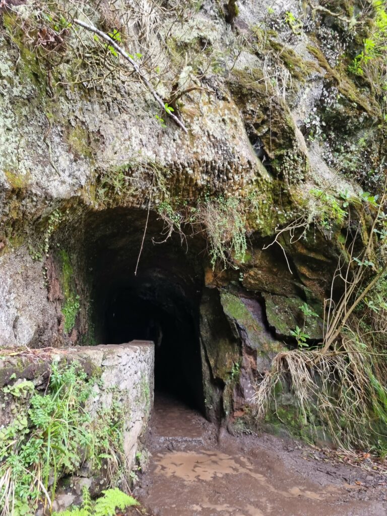 Wejście do ciemnego tunelu wykutego w skale na trasie PR 9.