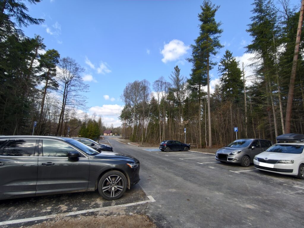 Darmowy leśny parking samochodowy i drewniane wiaty piknikowe na początku szlaku do rezerwatu Skałki Piekło pod Niekłaniem.