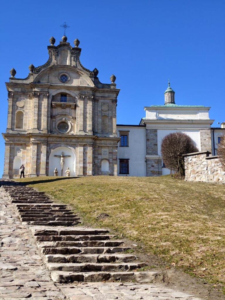 Przestronny dziedziniec zabytkowego opactwa na Świętym Krzyżu otoczony XV-wiecznymi gotyckimi krużgankami