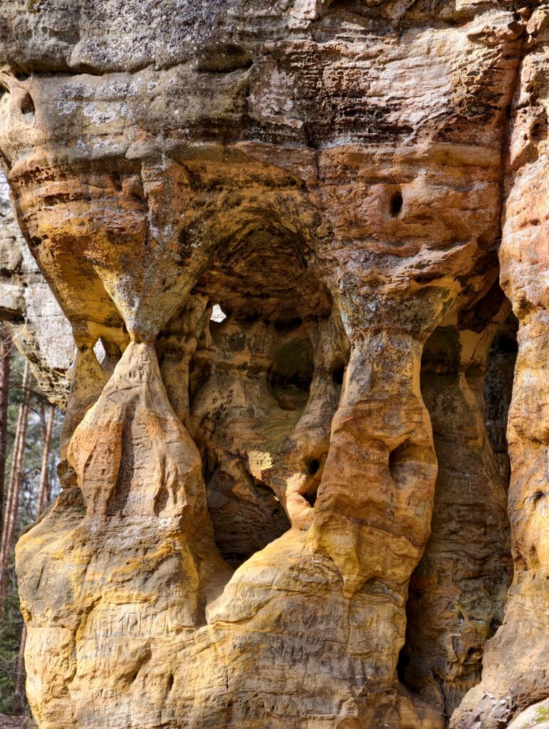 Mroczne szczeliny i płytkie jaskinie w formacjach skalnych rezerwatu Piekło pod Niekłaniem.
