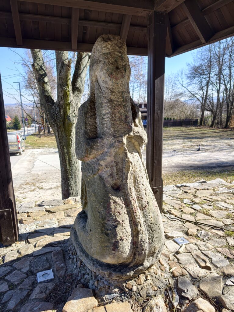 Kamienny posąg pielgrzyma Emeryka przy wejściu na niebieski szlak w Nowej Słupi.