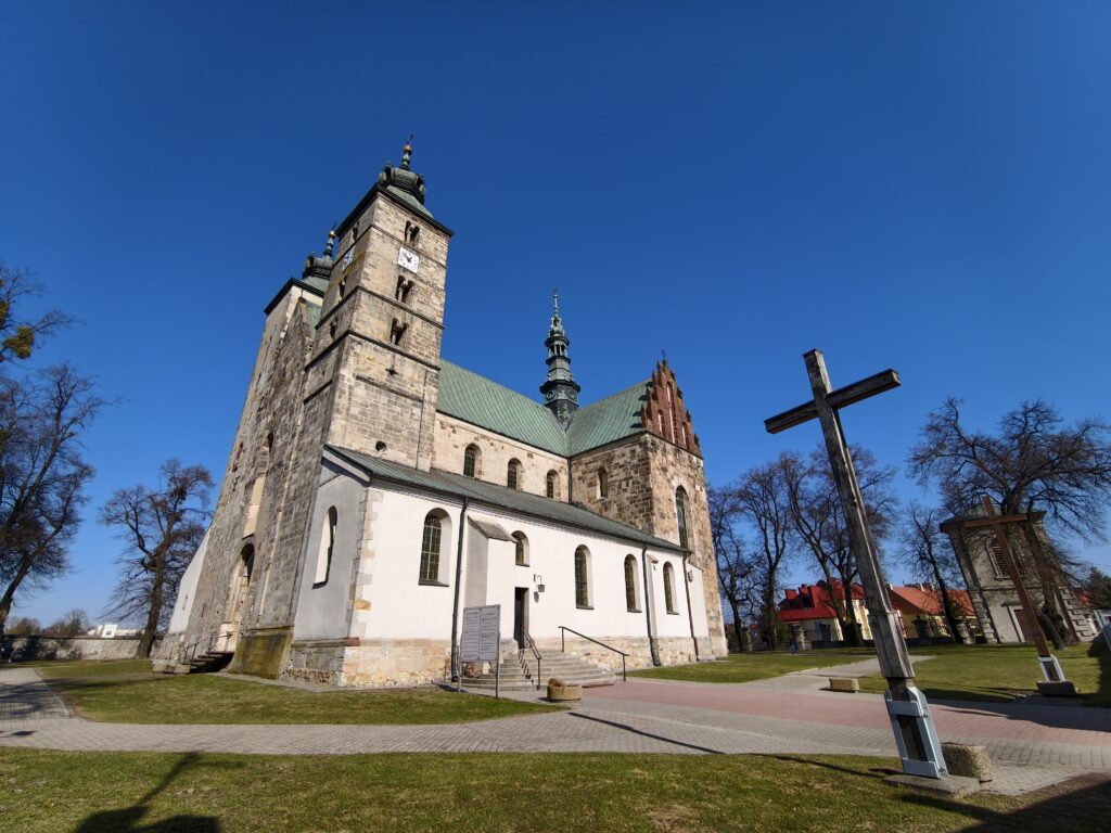 Majestatyczna romańska bryła Kolegiaty św. Marcina w Opatowie z dwiema wysokimi wieżami.