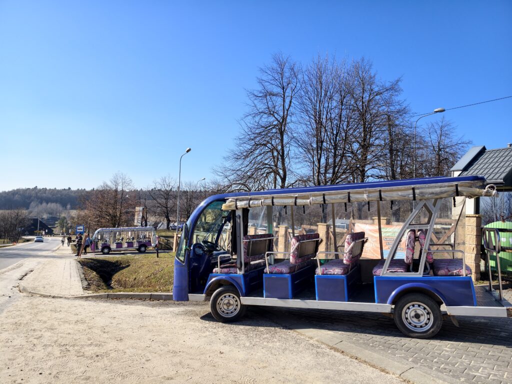 Pojazd elektryczny typu meleks na asfaltowej trasie czerwonego szlaku, wwożący turystów z Huty Szklanej na szczyt Łysej Góry