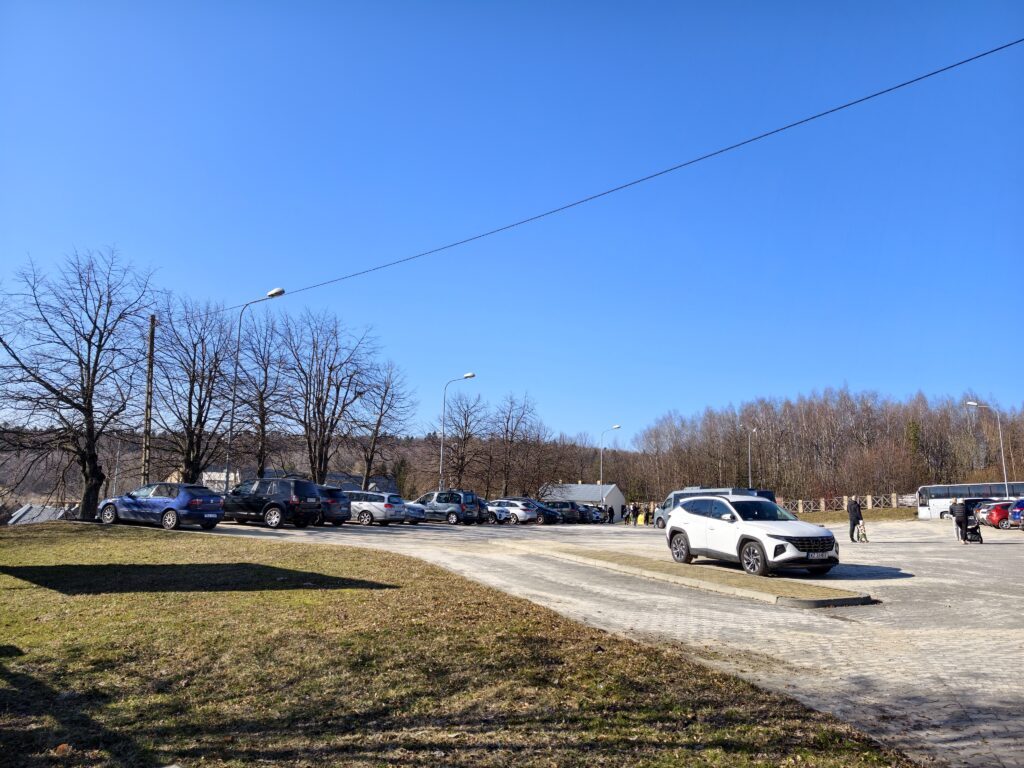 Obszerny parking dla samochodów osobowych w Hucie Szklanej, znajdujący się u podnóża Łysej Góry, tuż przed wejściem na czerwony szlak.