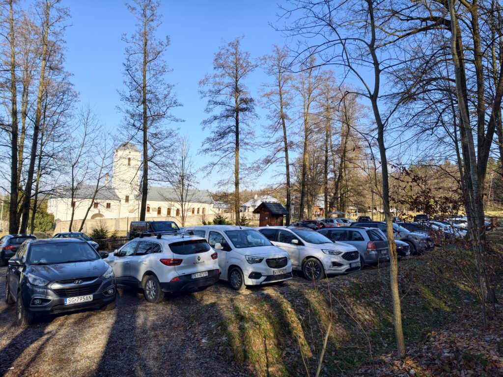 Samochody turystów na parkingu przy Klasztorze Bernardynek w Świętej Katarzynie przed wejściem na Łysicę.