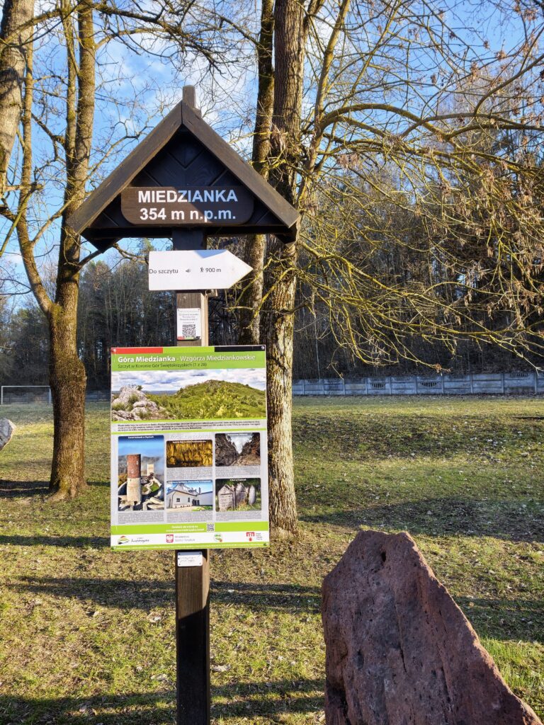 Tablica na początku szlaku wskazująca kierunek i czas wejścia na górę Miedzianka