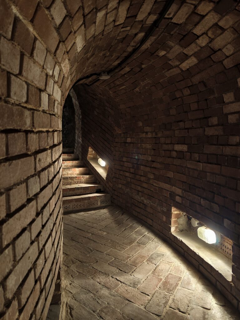Ceglane schody prowadzące do kolejnej, kondygnacji zabytkowych piwnic w opatowskich podziemiach.