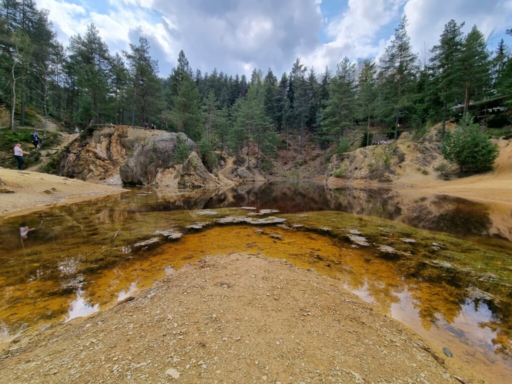 Krwistoczerwona woda Purpurowego Jeziorka i strome, rdzawe zbocza dawnej kopalni pirytu.