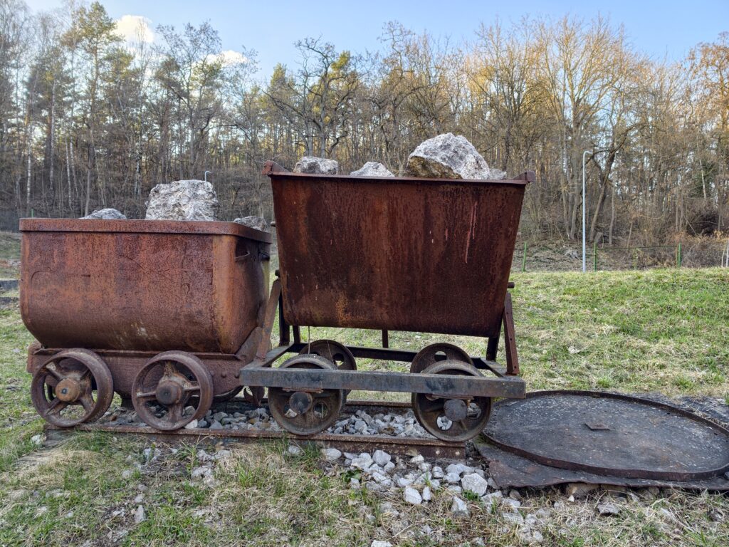 Zabytkowe, stalowe wagoniki kopalniane wyeksponowane na zewnątrz przed budynkiem Muzealnej Izby Górnictwa Kruszcowego w Miedziance.
