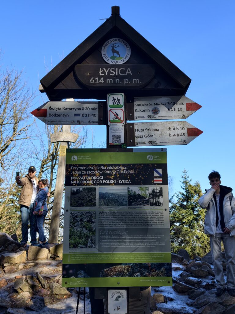 Drewniany znak turystyczny oznaczający szczyt Łysicy na wysokości 614 m n.p.m. w Górach Świętokrzyskich.