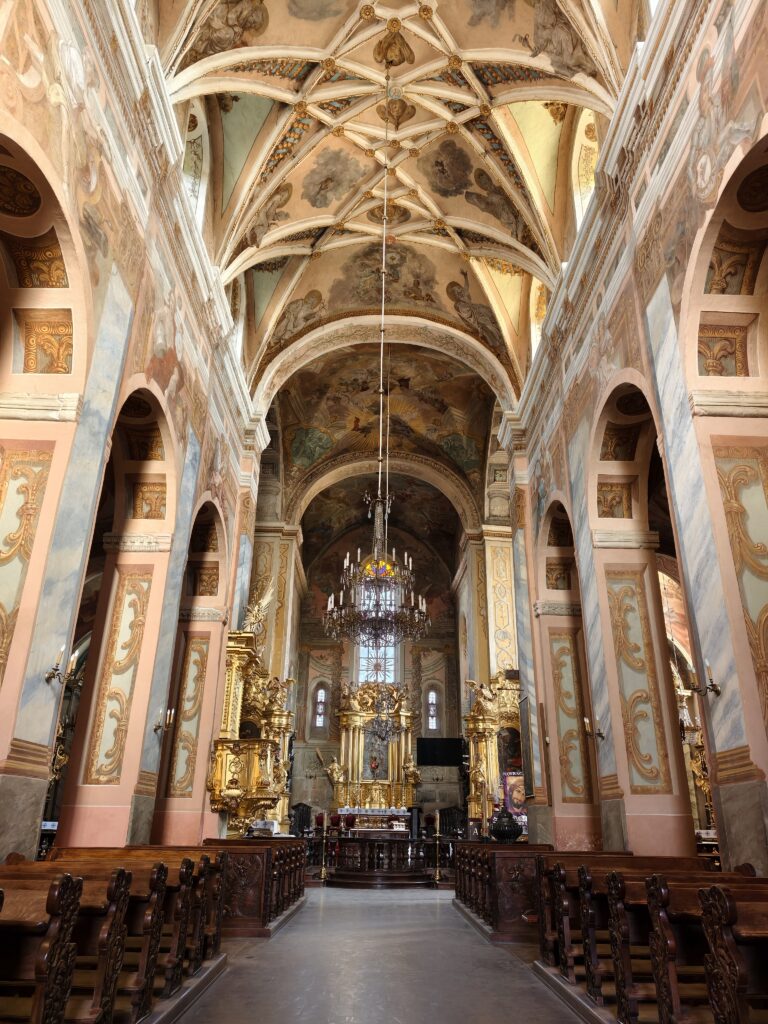 Szeroka panorama nawy głównej Kolegiaty św. Marcina w Opatowie z widocznym ołtarzem głównym, barokowymi polichromiami i romańskimi łukami. Opatów kolegiata to hit.