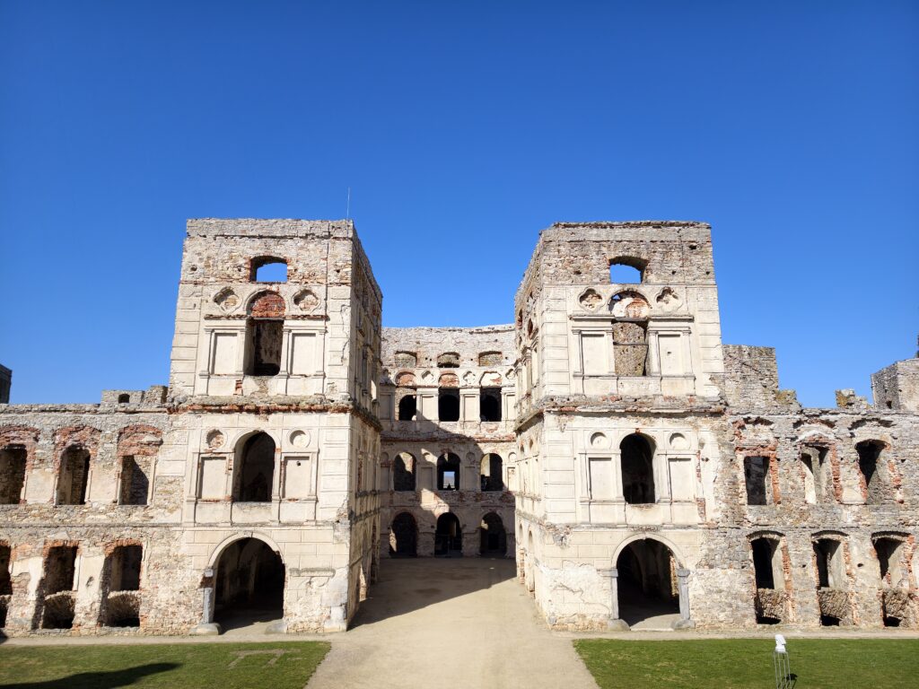 Szeroki kadr na dziedziniec eliptyczny Zamku Krzyżtopór w Ujeździe, prezentujący bogato zdobioną fasadę i symetryczne łuki pałacu.