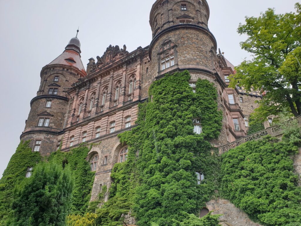 Majestatyczny widok na barokową fasadę Zamku Książ w Wałbrzychu. Monumentalne dwie kolumny boczne.