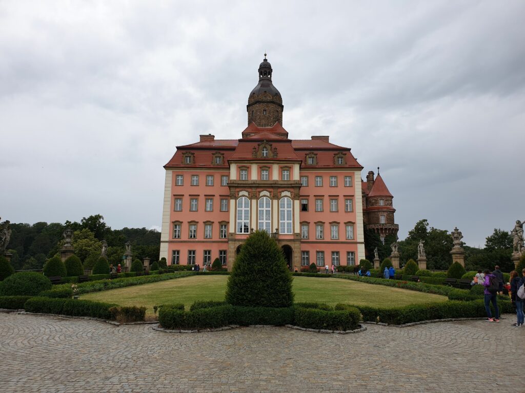 Majestatyczny widok na Zamek Książ w Wałbrzychu górujący nad wąwozem rzeki Pełcznicy, otoczony lasami Książańskiego Parku Krajobrazowego.