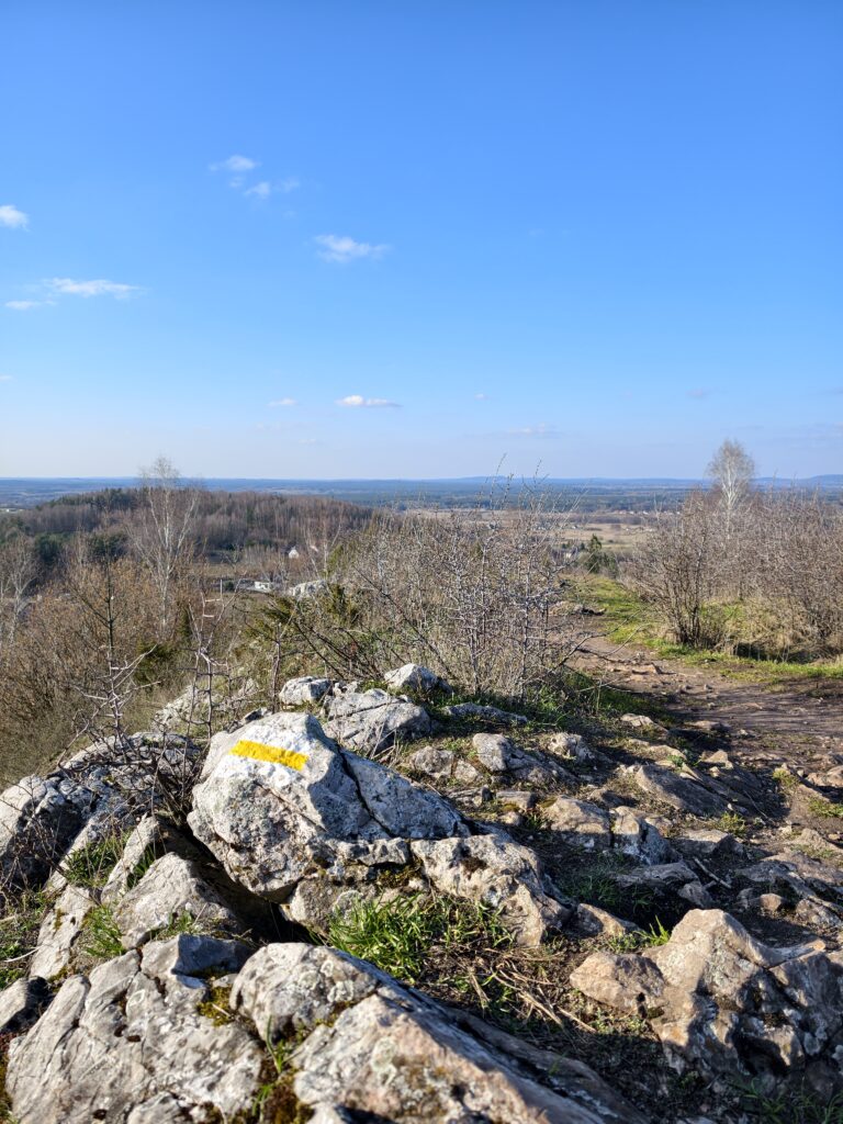 Namalowany na jasnej, wapiennej skale żółty znak szlaku turystycznego, wyznaczający trasę na samym szczycie góry Miedzianka.