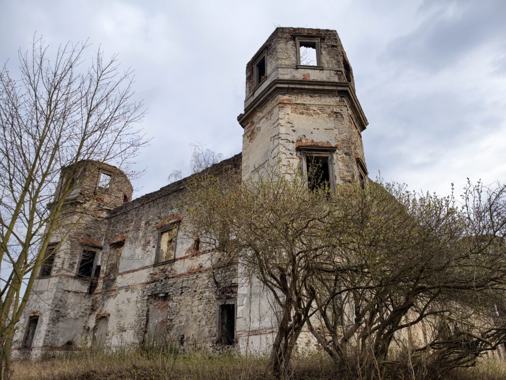 Widok z bliska na jedną z sześciobocznych wież narożnych i zachowane fragmenty barokowej elewacji Pałacu Tarłów.