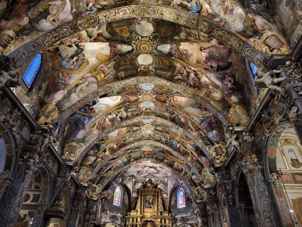 Imponujące wnętrze kościoła San Nicolás w Walencji, którego całe sklepienie i ściany pokryte są niezwykle barwnymi, bogatymi w detale freskami w stylu barokowym.