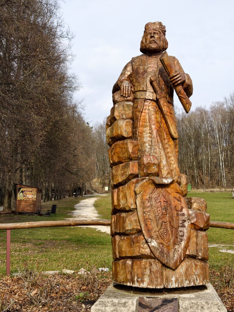 Drewniana, naturalnej wielkości rzeźba króla w Alei Królów prowadzącej na Zamek w Chęcinach