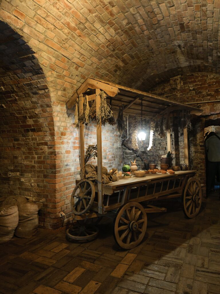 Wóz i eksponaty w podziemnej trasie turystycznej w Sandomierzu.