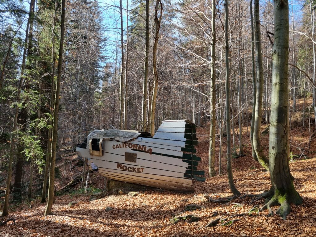Symboliczny, kamienny pomnik z zachowanymi fragmentami poszycia samolotu, upamiętniający katastrofę amerykańskiego bombowca B-24 Liberator.
