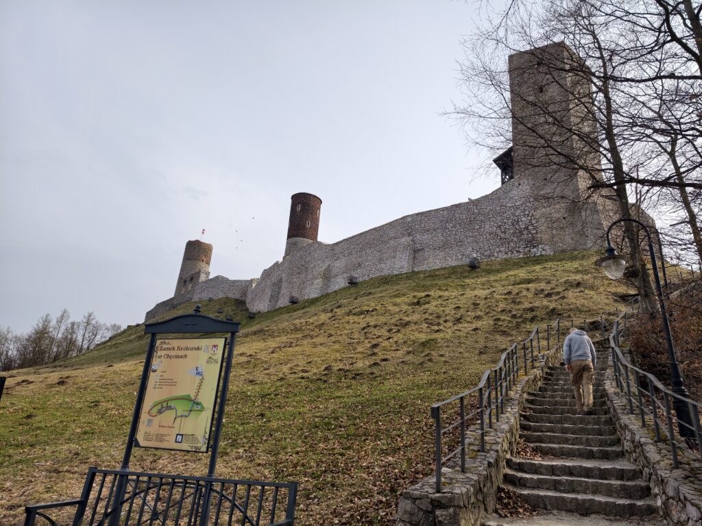Prowadząca pod górę malownicza ścieżka spacerowa z ruinami Zamku w Chęcinach majaczącymi w oddali