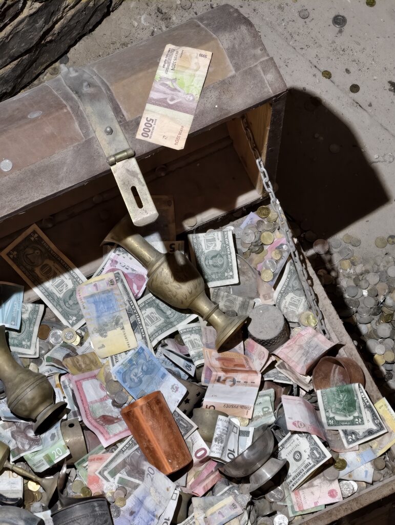 Zbliżenie na drewnianą skrzynię wypełnioną złotymi monetami w historycznym skarbcu królewskim na Zamku w Chęcinach