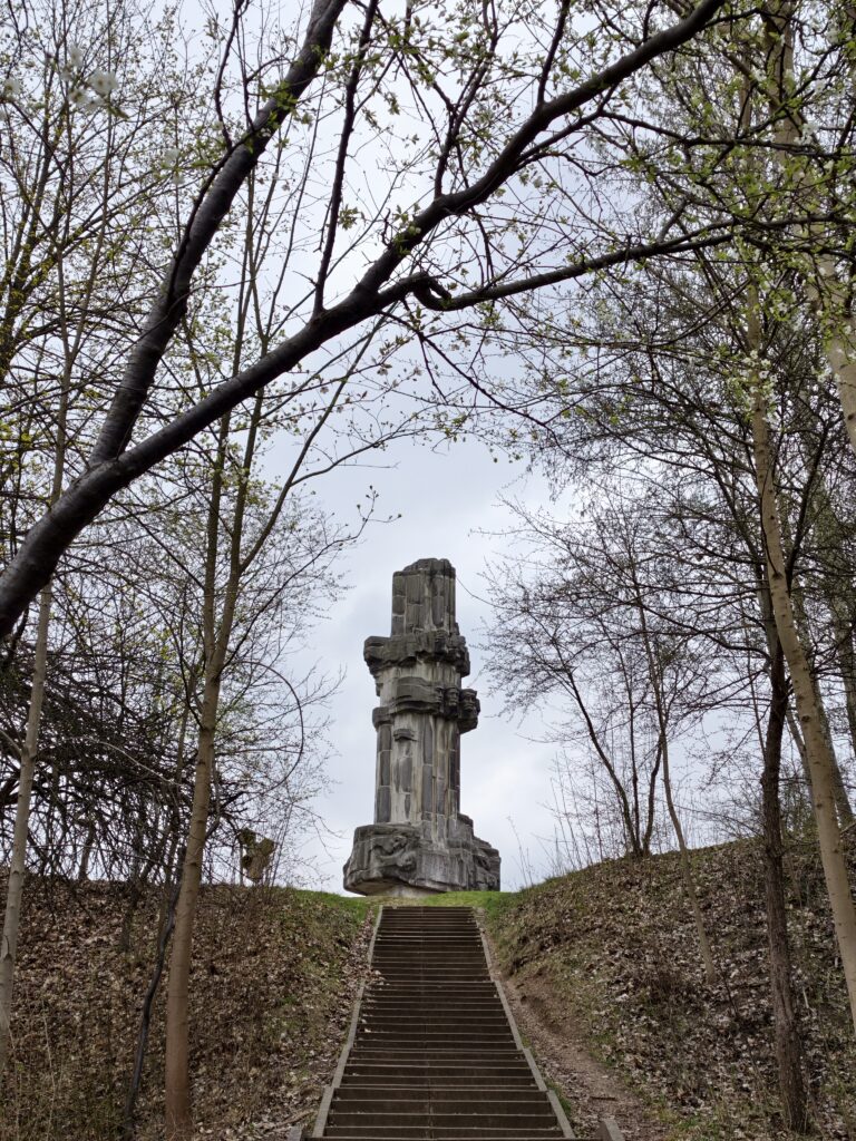 Schody na masywny, betonowy Pomnik Bojowników o Wyzwolenie Narodowe i Społeczne górujący na Wzgórzu Harcerskim w rezerwacie Kadzielnia.