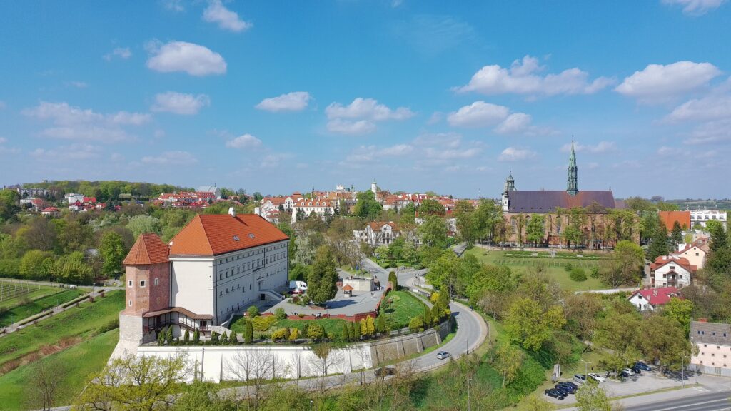 Monumentalna bryła Zamku Królewskiego z perspektywy drona w Sandomierzu położona na wysokiej skarpie wiślanej.