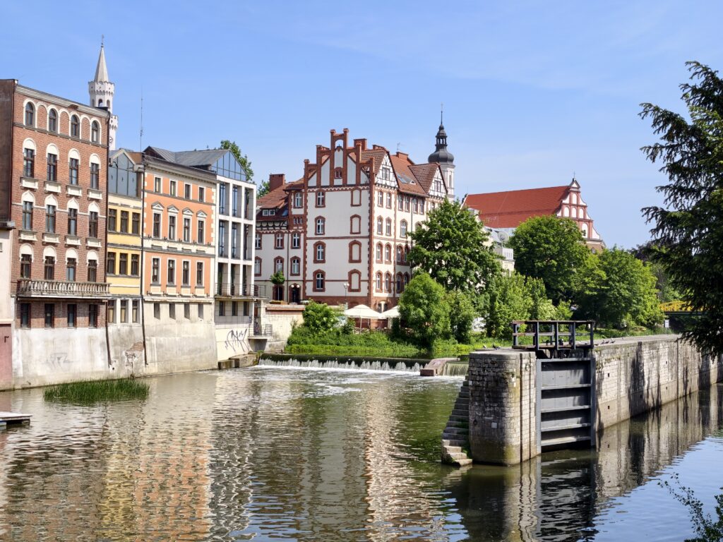 Kanał Młynówka w Opolu ze śluzą i zabytkowymi kamienicami opolskiej Wenecji odbijającymi się w wodzie
