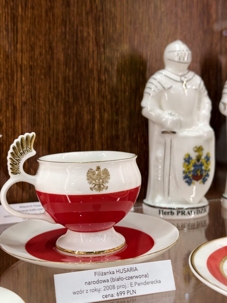 Ekskluzywna, biało-czerwona filiżanka porcelanowa Husaria ze złotym godłem Polski, na wystawie w muzeum w Ćmielowie.
