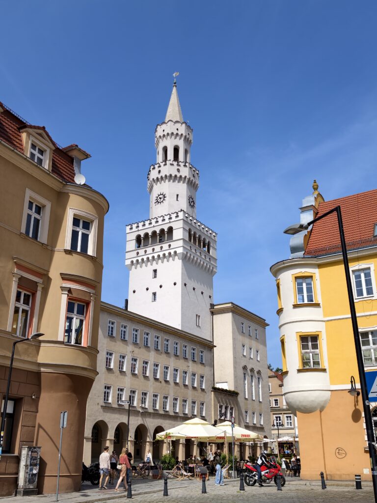 Biała wieża Ratusza w Opolu wzorowana na florenckim Palazzo Vecchio na tle błękitnego nieba